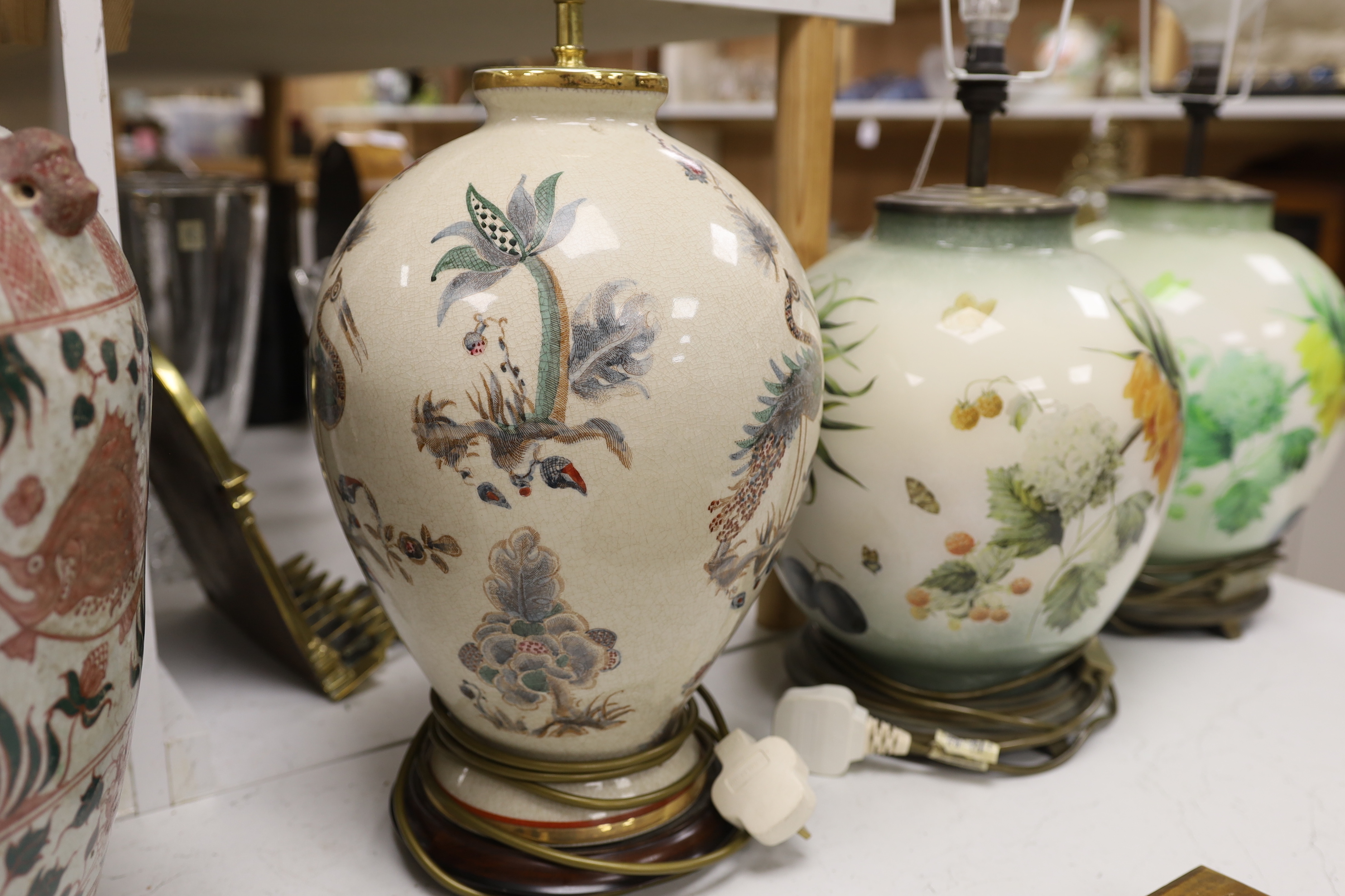 A pair of floral reverse decorated glass decorative table lamps and a similar crackle ware table lamp, 40cm not including light fitting